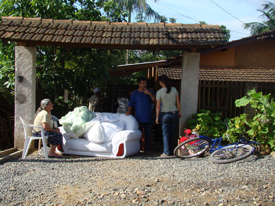 Vizinhos ajudam casal a retirar móveis da casa ameaçada (Foto de :Carolinne Sagaz)